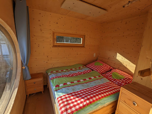 Schlafzimmer mit Zirbenbett und Bullauge